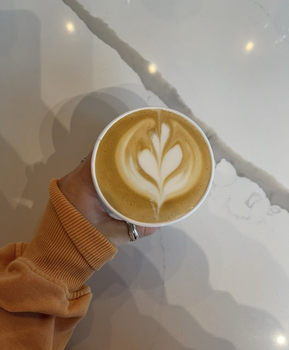 A latte held over a marble counter
